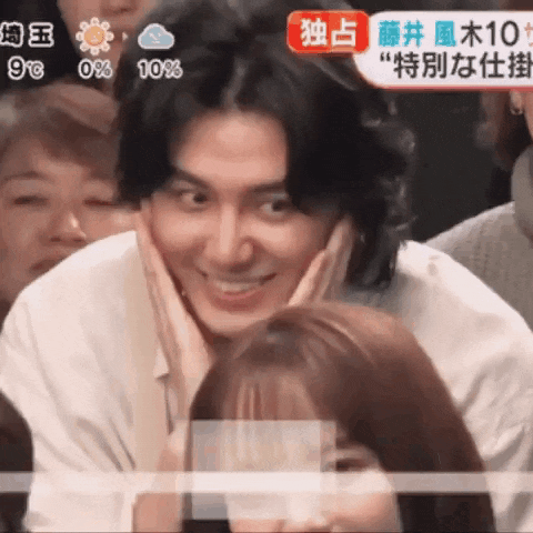 a man with his hand on his face is smiling in front of a group of people