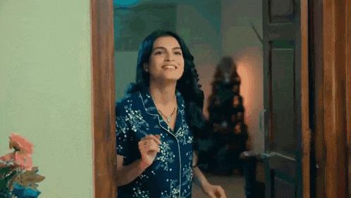 a woman is standing in a doorway in a room .