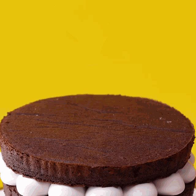 a chocolate cake with marshmallows on top is being poured with chocolate sauce