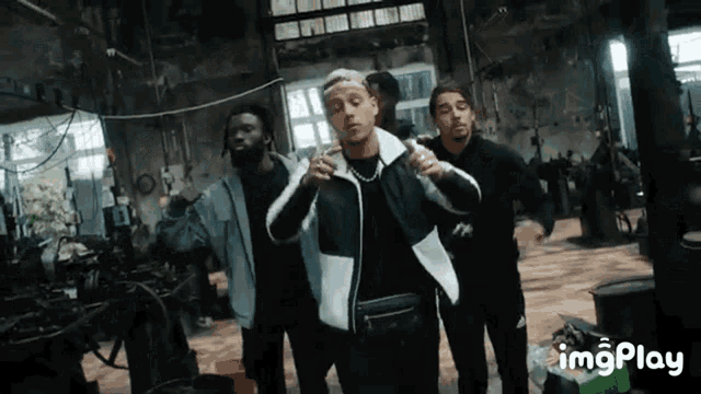 a group of men are standing next to each other in a room in a factory .