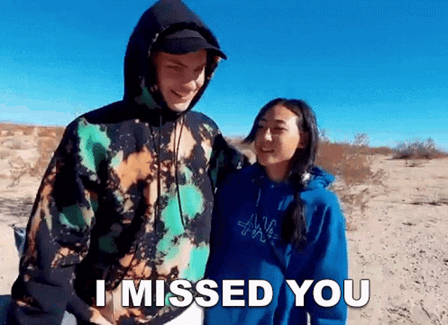 a man and a woman are standing next to each other in the desert and the man is saying i missed you