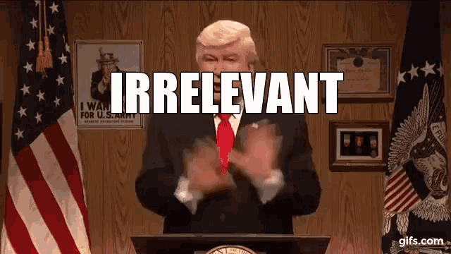a man in a suit and tie is giving a speech and the word irrelevant is behind him