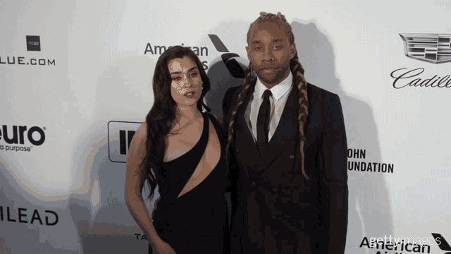 a man and a woman pose for a photo on a red carpet that says lead on it