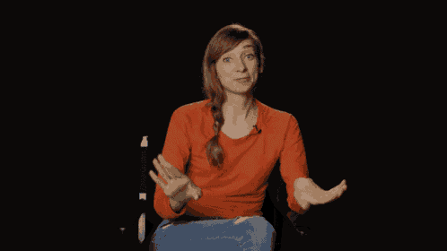 a woman in a red sweater is laughing and covering her nose