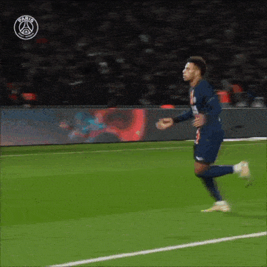 a soccer player is running on a field with the paris saint-germain logo behind him