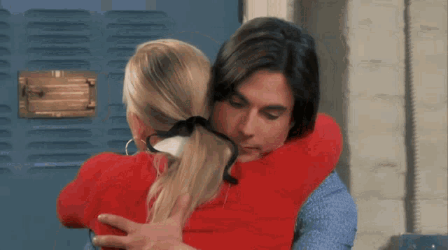 a woman in a red sweater is talking to a man