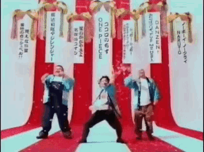 a group of men are dancing on a red carpet in front of a banner that says one piece .
