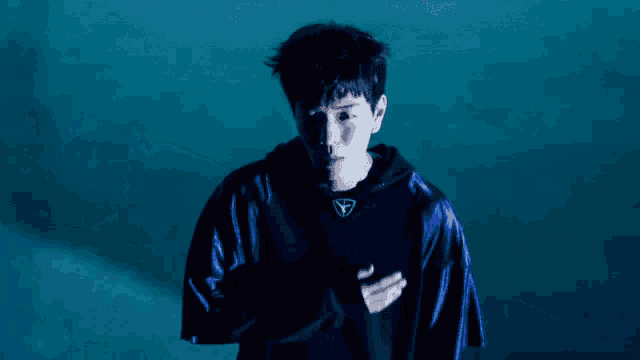 a man wearing a blue jacket with a triangle on the front