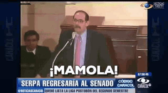 a man in a suit and tie is giving a speech in front of a microphone on a television screen .