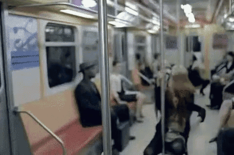a blurry picture of a subway car with people sitting on it .