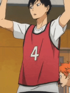 a man wearing a red vest with the number 4 on it is standing in a gym .
