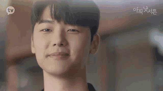 a close up of a young man 's face with a smile on his face