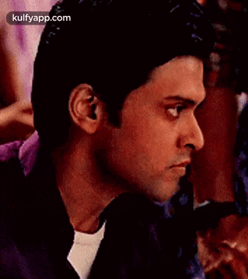 a man in a purple shirt is making a funny face .