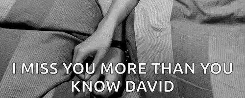 a black and white photo of a couple holding hands on a bed with the words `` i miss you more than you know david '' .