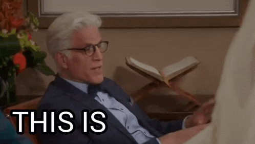 a man in a suit and tie is sitting in a chair with the words this is on the screen .