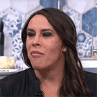 a woman with long brown hair is making a funny face while sitting in front of a microphone .
