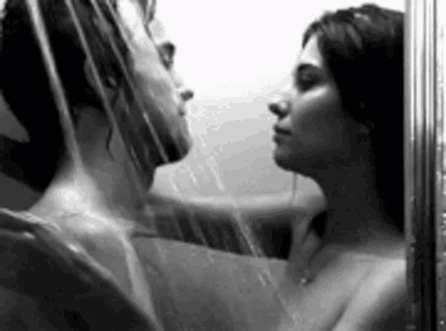 a black and white photo of a man and a woman taking a shower
