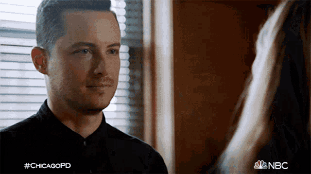 a man in a black shirt is looking at a woman in front of a window with the hashtag #chicagopd