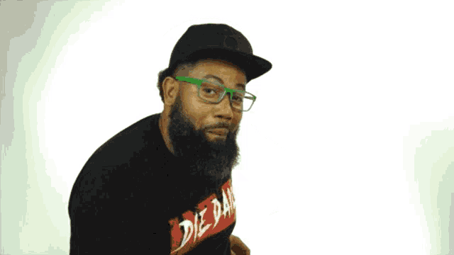 a man with a beard wearing glasses and a shirt that says de ban