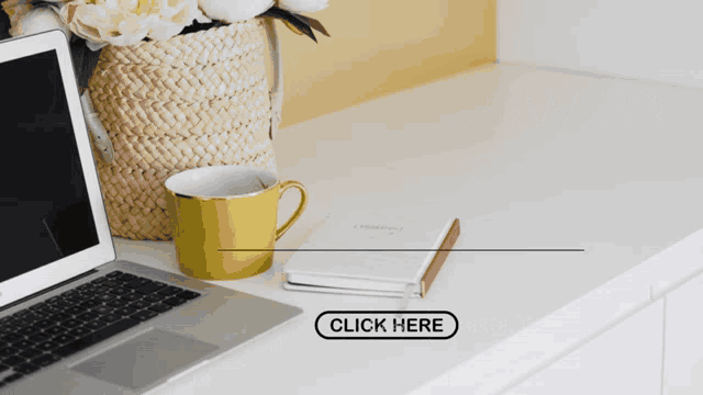 a laptop sits on a desk next to a yellow cup and a notebook