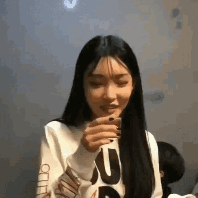 a woman wearing a white sweatshirt with the letter u on the arm