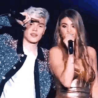 a man and a woman are standing next to each other on a stage .