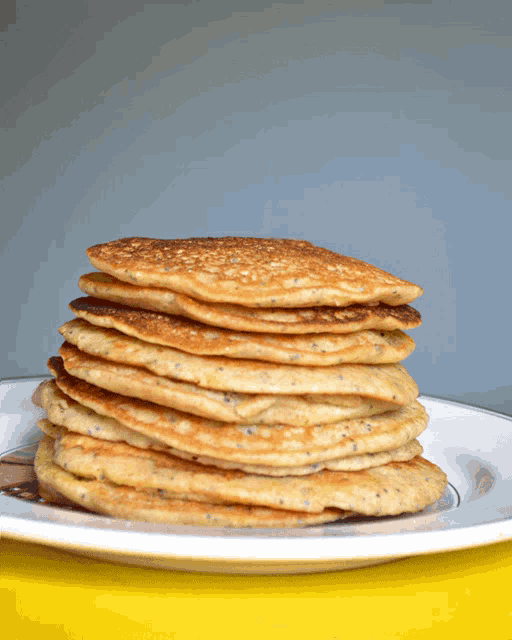a stack of pancakes is on a white plate
