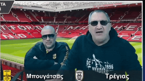 two men are standing in front of a soccer field and one of them is wearing a shirt that says dc 1996 invaders