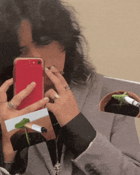a woman taking a picture of herself with a cell phone