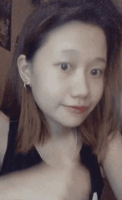 a close up of a woman 's face with a black tank top on