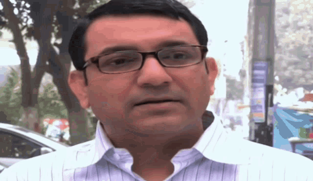 a man wearing glasses and a white striped shirt