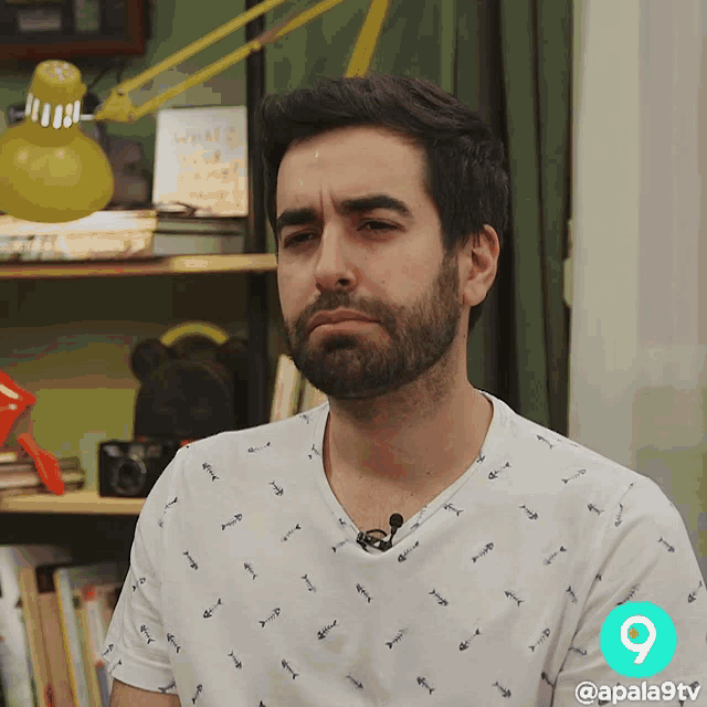 a man with a beard and a white shirt with fish on it
