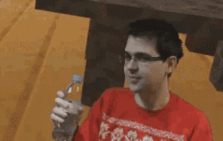 a man in a red sweater is holding a bottle of water