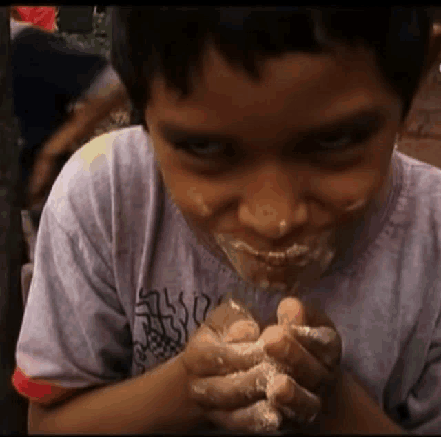 a young boy wearing a shirt that says ' sss ' on it is eating something