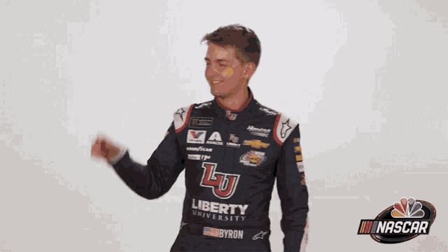 a man wearing a liberty university jersey is waving his hand