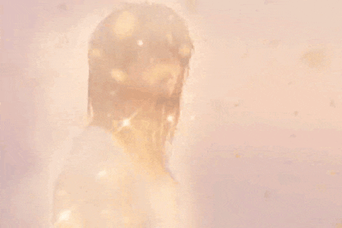 a woman with long blonde hair is standing in a bathtub with water coming out of her hair .