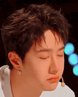 a close up of a young man 's face with his eyes closed and a microphone in his ear
