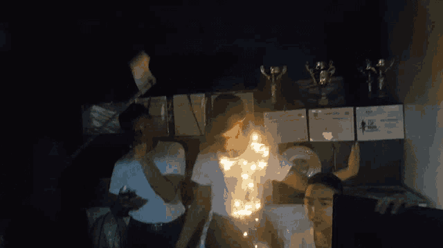 a group of people in a dark room with trophies on the wall
