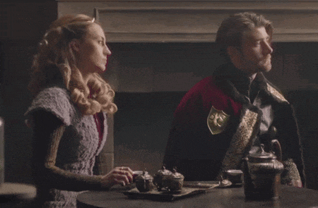 a man and a woman are sitting at a table with a tray of tea