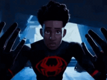 a man is standing in a dark room with a red hand reaching out of the ceiling .