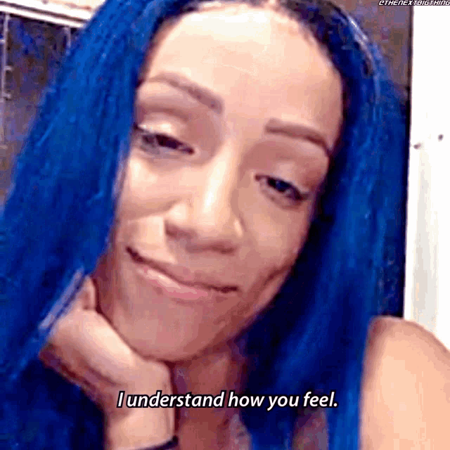 a woman with blue hair is smiling and saying i understand how you feel .