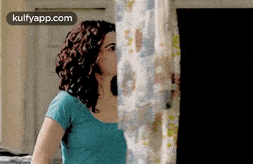 a woman is kissing a shower curtain in a bathroom .