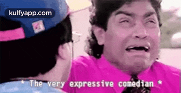 a man in a pink shirt and tie is crying in front of another man .