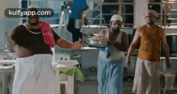 a group of men are standing next to each other in a kitchen holding pots and pans .