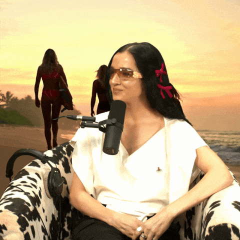 a woman sitting in front of a microphone on the beach