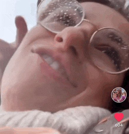 a close up of a woman wearing glasses with the number 604 on the bottom right