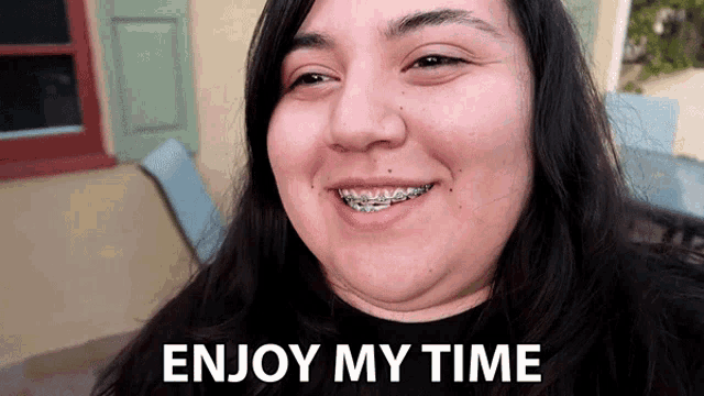 a woman with braces smiles with the words enjoy my time written below her