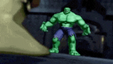 a hulk action figure is standing on a sidewalk in a dark room .