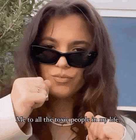 a woman wearing sunglasses and a ring is giving the middle finger .