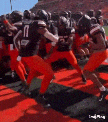 a group of football players are running on a field and one of them has the number 2 on his jersey